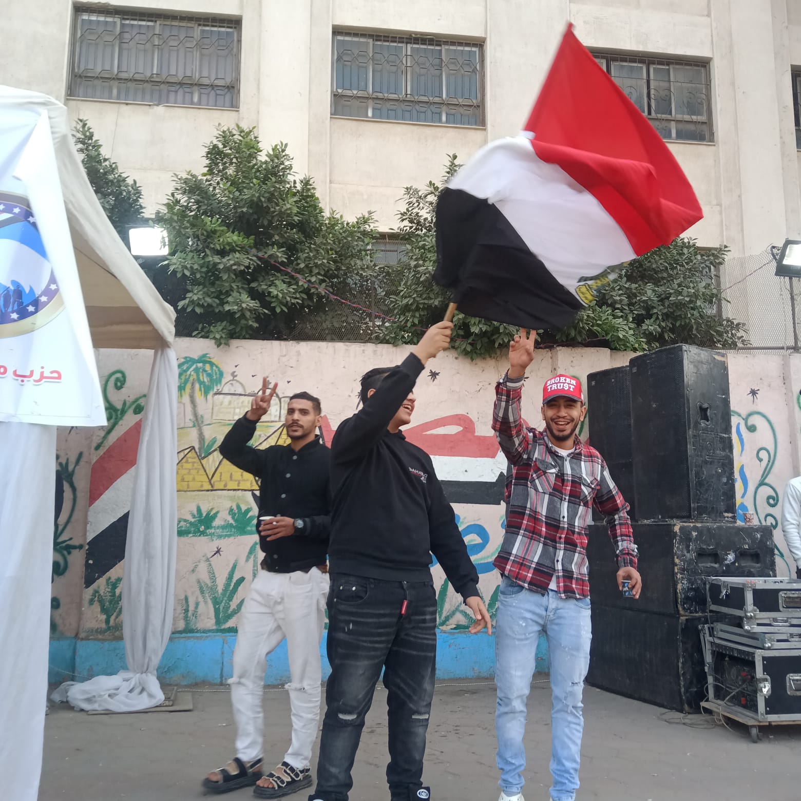 شباب يرفعون العلم المصري أمام اللجان المصرية القديمة